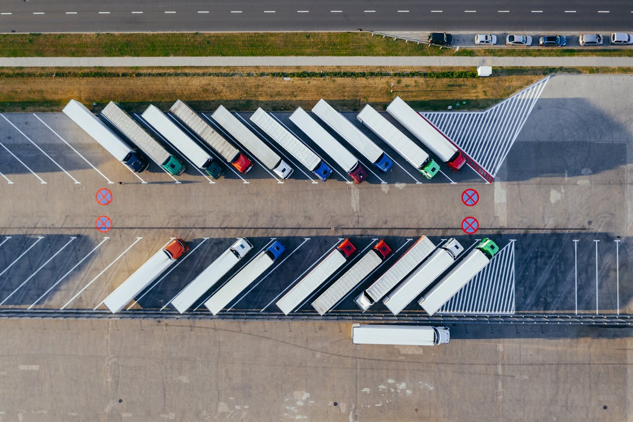 Home Overhead shot of semi-trucks parked in Poznań, Poland, demonstrating transportation logistics.